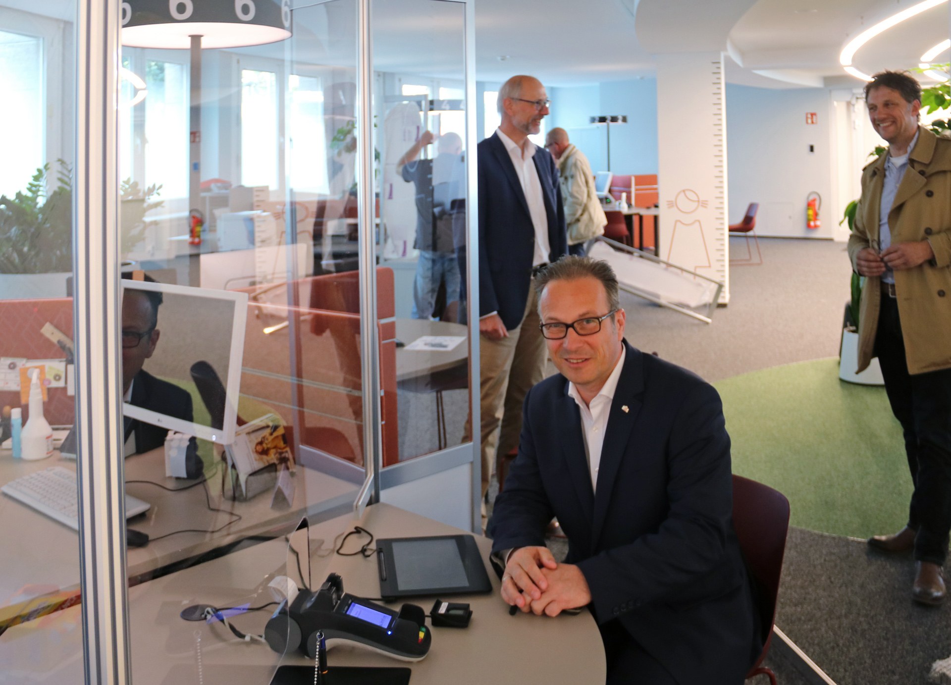 Bürgermeister Reiner Breuer mit den neuen Hygieneschutzwänden, im Hintergrund v.l.: Uwe Neumann, Amtsleiter Bürger- und Ordnungsamt und Maximilian Schäfer, Abteilungsleiter Gebäudemanagement Neuss